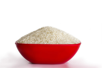 Uncooked rice in a bowl isolated on white background