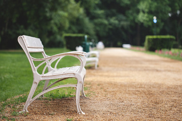 a white bench stands in the park.