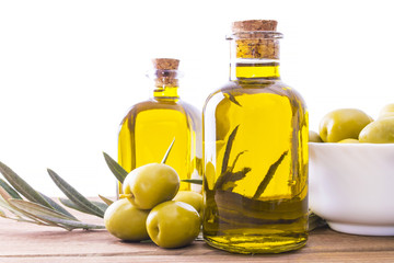 bottles of extra virgin olive oil and bowl of olives isolated on white