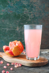 Ripe pomegranate with glass of pomegranate juice on rustic background
