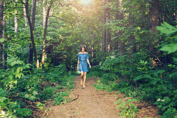 Naklejka na ściany i meble Nature, people and lifestyle concept - Beautiful young woman in dress runing in the summer forest