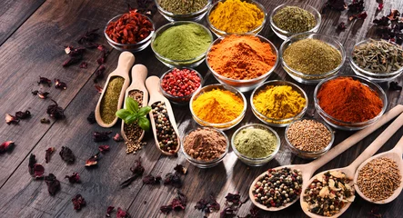 Fotobehang Verscheidenheid aan specerijen en kruiden op keukentafel © monticellllo