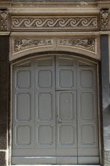 antica porta di ingresso in legno grigio, ornamenti in pietra scolpita