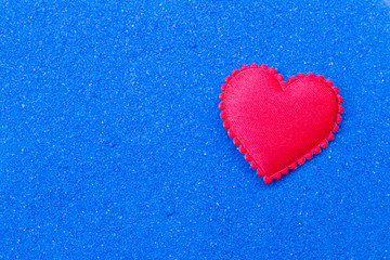 Red heart on blue sand