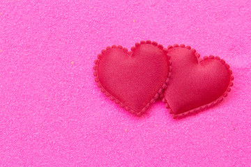 Red heart on pink sand