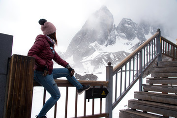 Tourist woman standing and looking at beautiful view of Yulong snow mountain or Jade dragon snow...