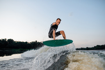 Wakesurfer riding down the river on a blue board