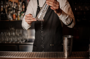 Barman preparing ice for making fresh summer cocktail