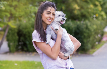 Beautiful Smiling Woman Hugging  Her Cute Havanese Dog .Pet and Owner Outdoor