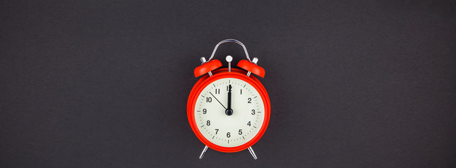 Red vintage alarm clock on dark background