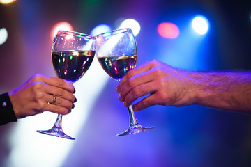 Cheerful couple clinking glasses of champagne at the party