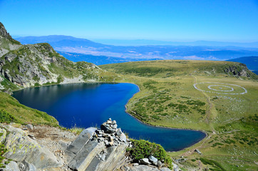 One of the 7 Rila lakes in Bulgaria with a group of people forming a circle