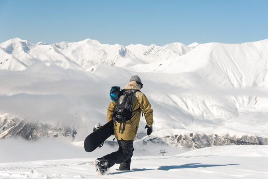 snowboarder on the background of mountains and blue sky.