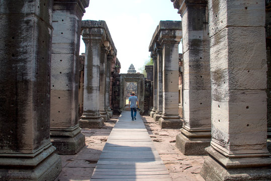 Tourist man walking at PRASAT HIN PIMAI is historic, ancient castle of generality in NAKHON RATCHASIMA Thailand and a kind of Khmer architect art decorated in the Buddhist temple,pavilion,temple hall