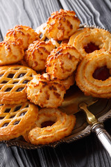 Dessert biscuit cookies in a close-up assortment on a platter on a black. vertical