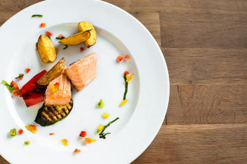 Grilled salmon and vegetable on wooden table