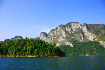 Landscape of Dam with Mountain and river near forest hills in Blue sky at Ratchaprapha Dam at Khao Sok National Park, Surat Thani Province, Thailand.