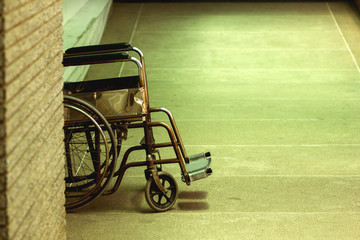 Very old wheelchair for patients left alone in the hospital.