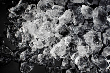 Stack of melting ice on black background