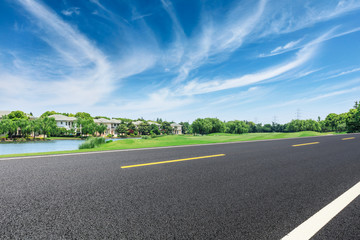 Fototapeta premium Asphalt road and apartment building scene in the suburbs of the city