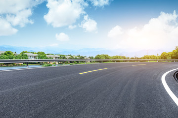 Fototapeta premium Asphalt road and apartment building scene in the suburbs of the city