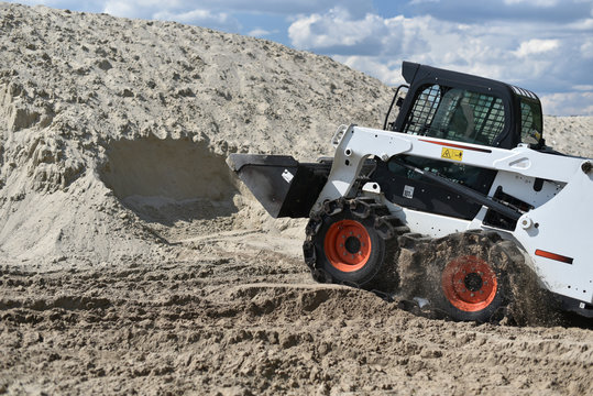 skid-steer loader working with sand 