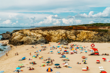 People Having Fun In Water, Relaxing And Sunbathing On Algarve Beach In Portugal
