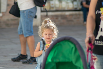 Little girl walking and eating an ice in Venice Italy 