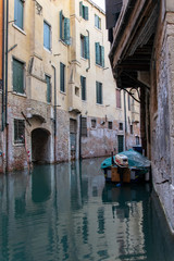 View of a docked boat on a hidden water channel in Venice Italy 