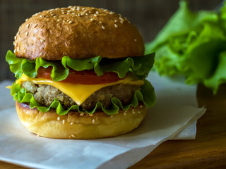 Hamburger is big. Cheeseburger's on the table. The unhealthy food. The concept of healthy eating.