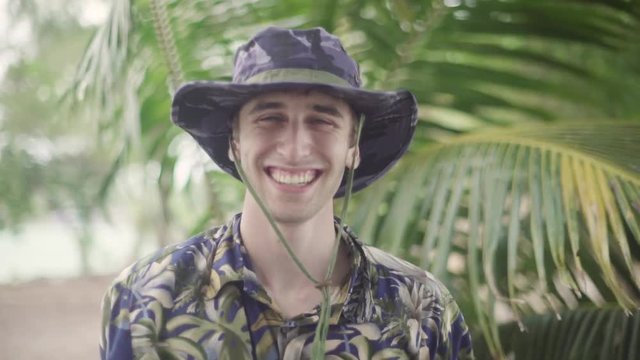 Tropical Jungle Explorer - Steve Irwin Esque. Puts on his wide brim hat and stares into the camera in tropical setting