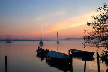 Boote am Seeufer im Sonnenaufgang