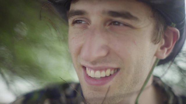 Close up - attractive white male smiling into the distance in tropical jungle setting