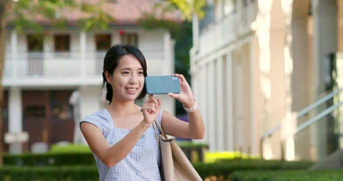 Woman taking photo on cellphone at outdoor