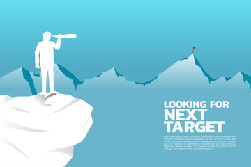 Silhouette of businessman looking through telescope to target on top of far mountain. business concept looking for next target and opportunity.