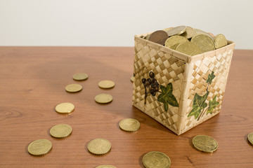 Box full of euro coins on a wood table