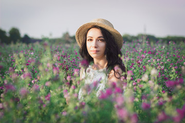 Beautiful young woman on the field of clover