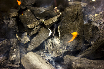Burning coals at day; barbeque season, decaying charcoal.