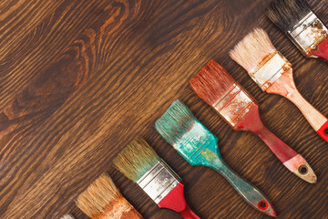 Different colorful brushes on the wooden background