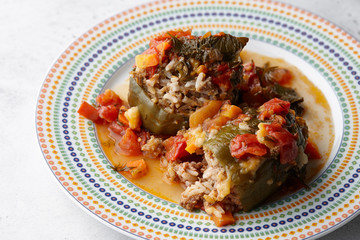 Peppers stuffed with meat and bulgur in round mosaic plate, close up view
