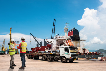 foreman and supervisor in charge working in sea port terminal take control trailers trucking cargo delivery shipment from yard delivery to the ships vessel in port