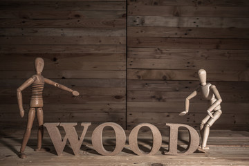 wooden puppets with wood word on wood table in wood scene