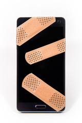 smartphone with sticking plasters. The phone looks like damagged or medicated
