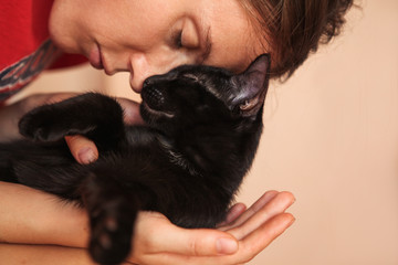 Woman is holding and hugging her cute cat.