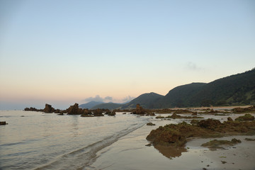 Fototapeta na wymiar Sunset on a beach with mountains