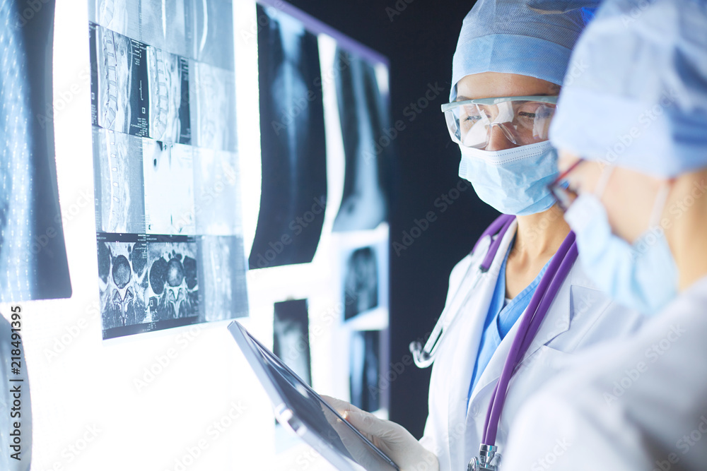 Wall mural Two female women medical doctors looking at x-rays in a hospital.