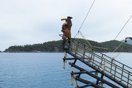 The figure of a pirate on a ship's gangplank looks out into the distance of the sea