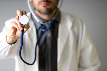 An unidentified doctor grabs a stethoscope to the camera to check the patient