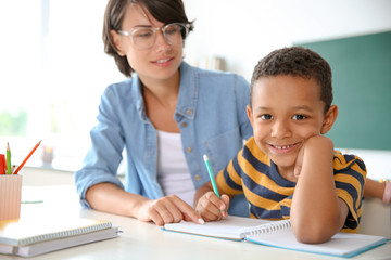 Female teacher helping child with assignment at school