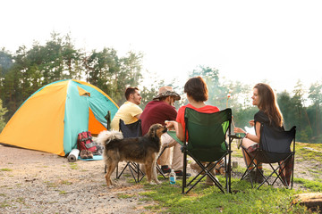 Fototapeta premium People having lunch near camping tent outdoors